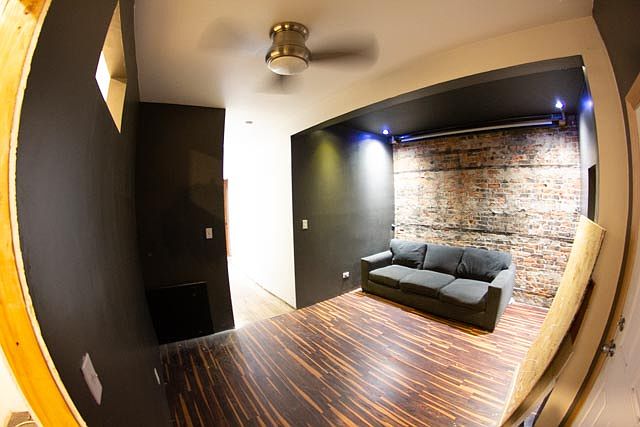 home theater at end of hallway. cut out in wall on left to allow projector in closet to show on movie screen