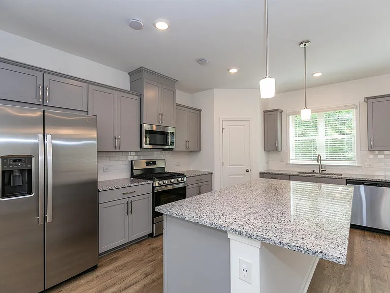 Modern kitchen featuring gray cabinets and granite countertops.