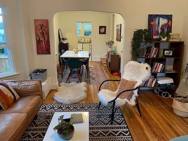 Living room looking into dining and kitchen. Hardwood floors recently refinished. Lovely archway, bay window to the south, custom blinds (not pictured here, have been installed since photo was taken) throughout home.