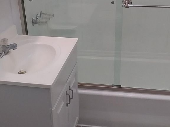 Bathroom leads to hallway with bedrooms on both ends.