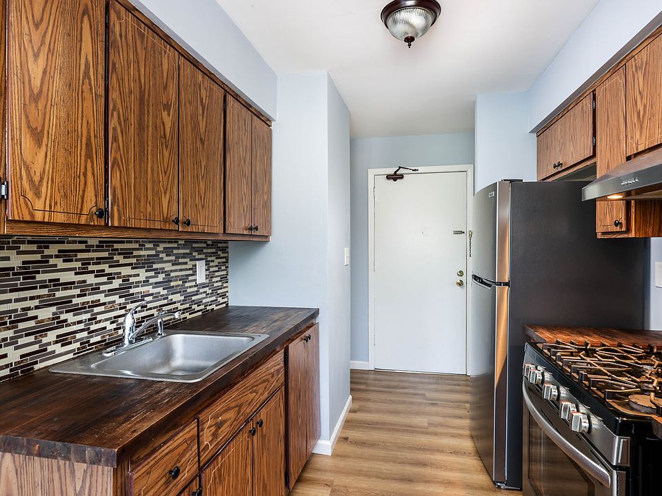 Updated Galley kitchen has a self/cleaning gas stove, refrigerator, mosaic tile backsplash on refinished countertops.