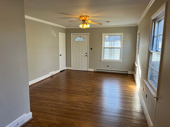 Living room and dining room. Just-refinished hardwood floors. Attractive door and heavy storm door.