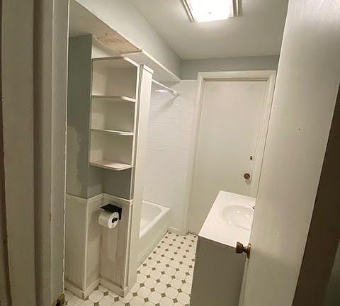 bathroom off the kitchen, separated by a wall/hallway.