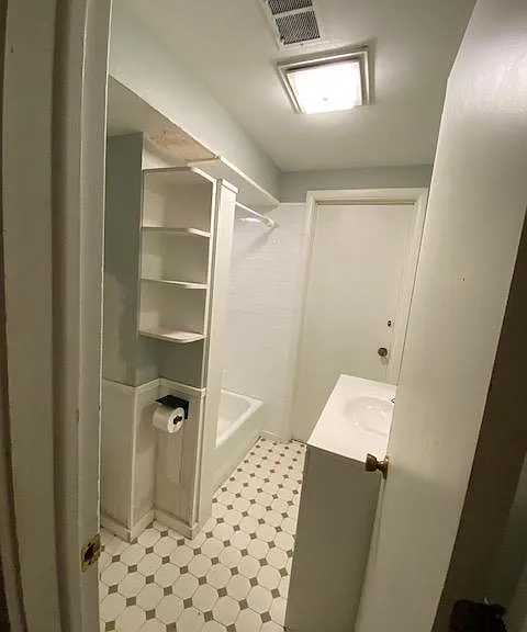 bathroom off the kitchen, separated by a wall/hallway.