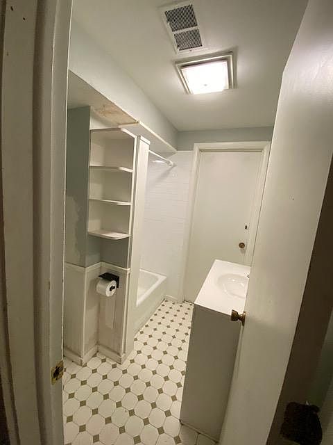 bathroom off the kitchen, separated by a wall/hallway.