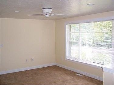 Spacious living room with a large front window shower and w/w carpet.