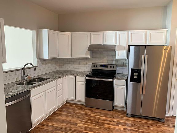 Kitchen with Back splash and Refrigerator