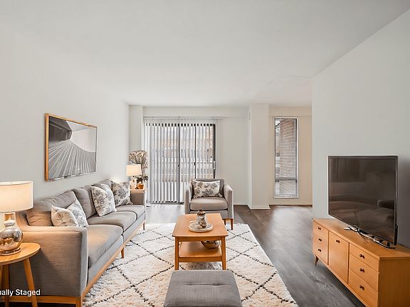 A living room with a grey couch, a wooden coffee table, and a television.