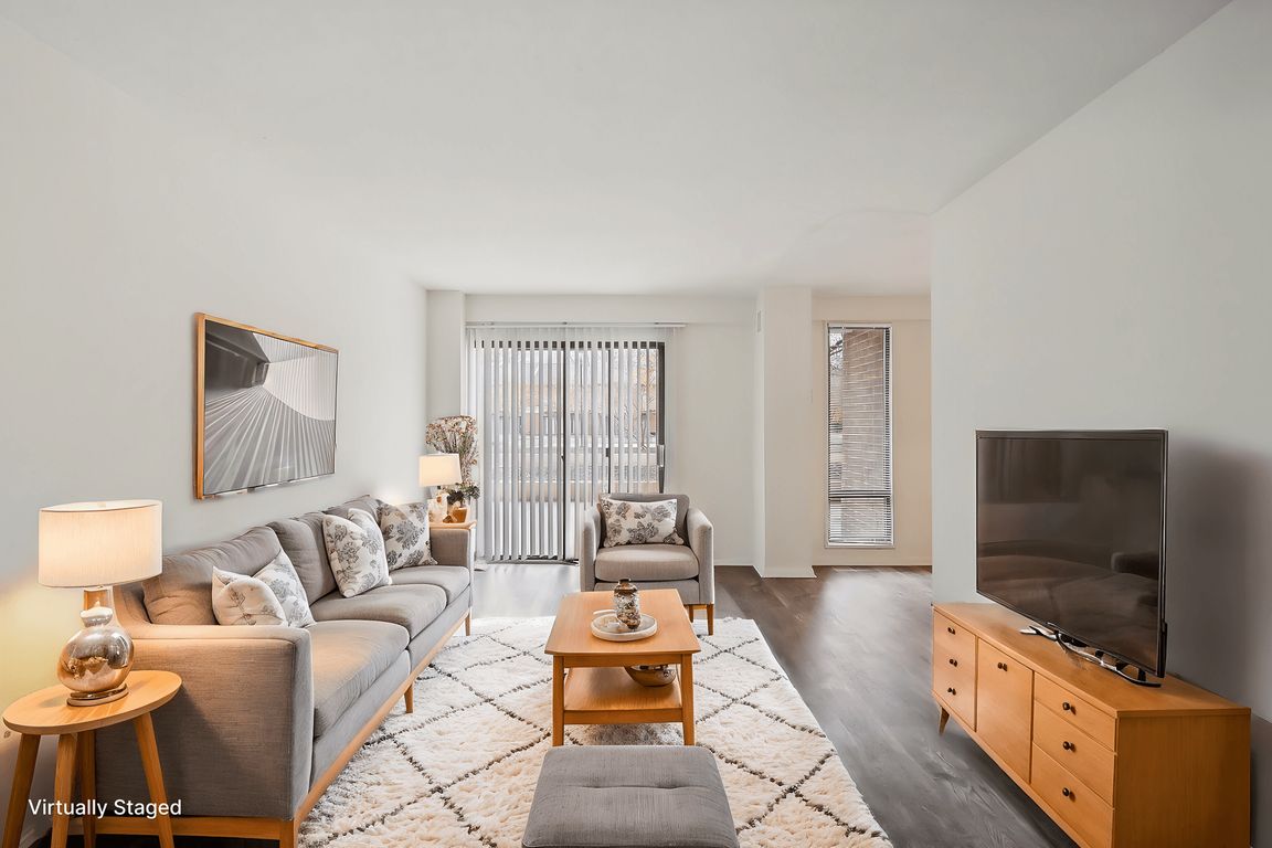 A living room with a grey couch, a wooden coffee table, and a television.