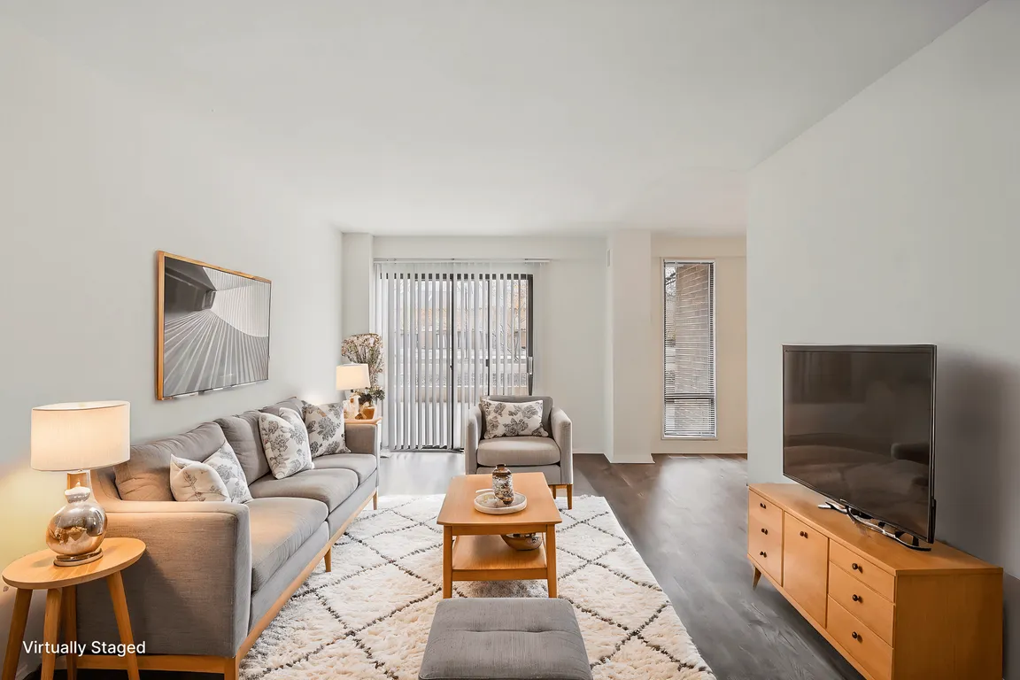 A living room with a grey couch, a wooden coffee table, and a television.