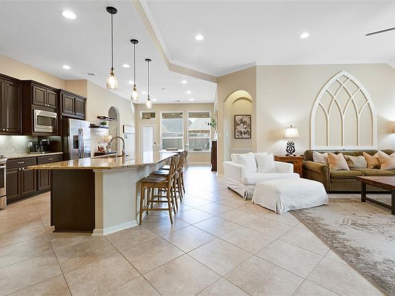 Open floorplan with plenty of space for entertaining. Note extensive crown molding, archways and natural light