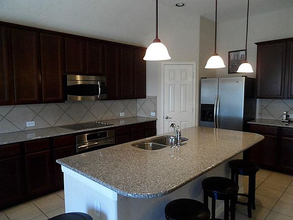 Moving on to the kitchen, it overlooks the living are,  you have granite counters,  tile back splash with tile flooring