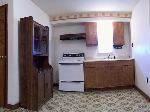 Linoleum flooring continues from the kitchen into the hallway.