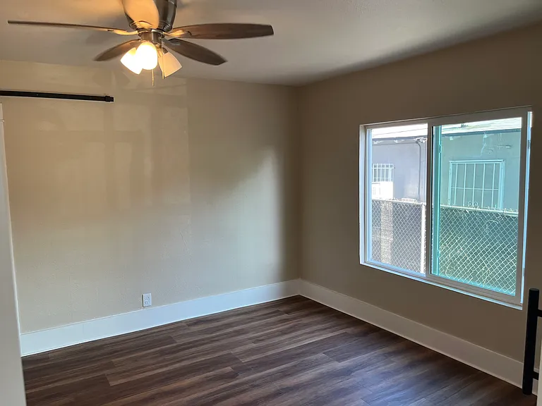 Bedroom 1 has a large window to let in natural light.