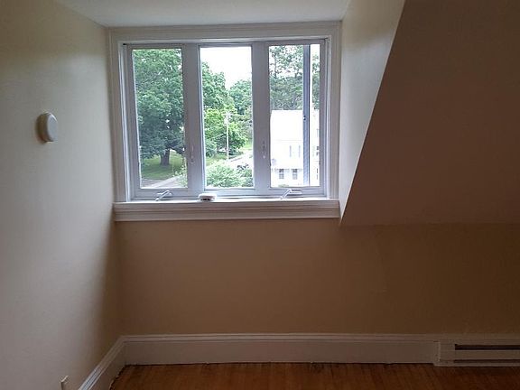 Bedroom with window out to side yard. Newly finished original hardwood floors.