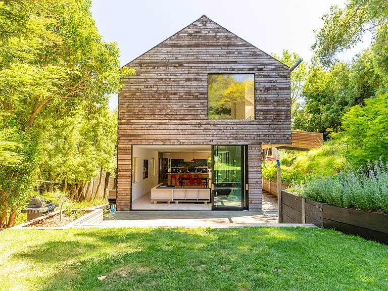 Rear of the home with siding doors open to large wooden deck