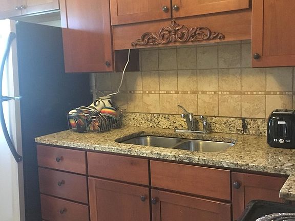 Kitchen has a lovely granite counter top and beautiful wood cabinets.(washer and dryer combo is provided and is in the kitchen)
