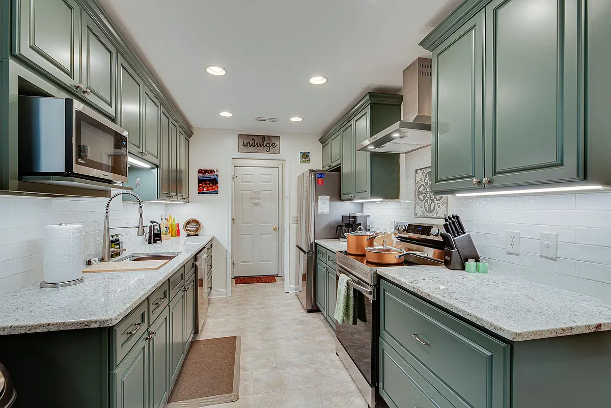 Chef's kitchen with gorgeous green cabintry & stainless steel appliances - Double Tree Way