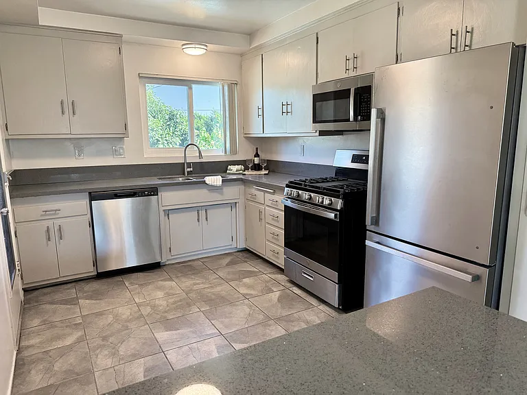 Chef's kitchen with semi-pro gas range, quartz counters & bar.