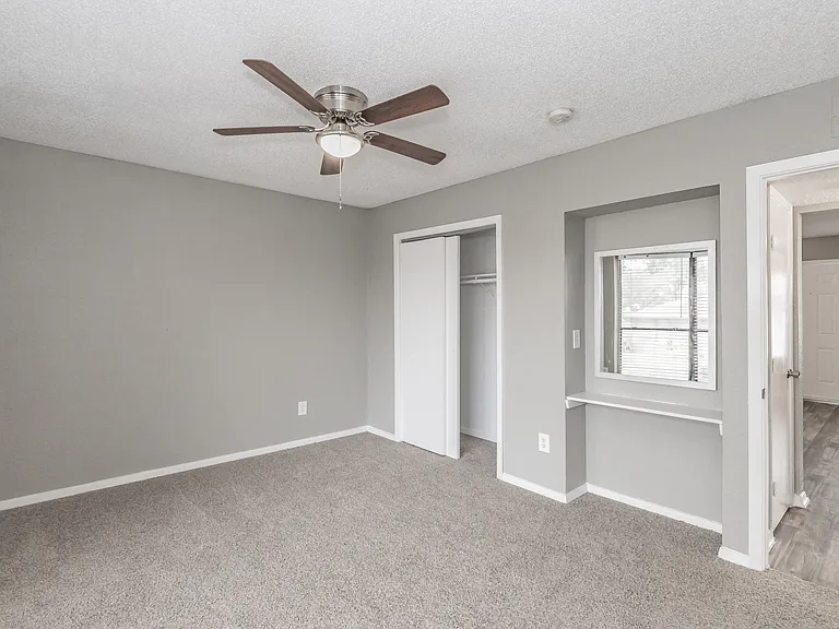 Bedrooms feature neutral finishes, ceiling fans, and ample natural light at Chapel Creek Apartments.
