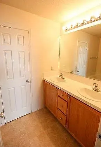 Primary bathroom vanity with double sinks and storage.