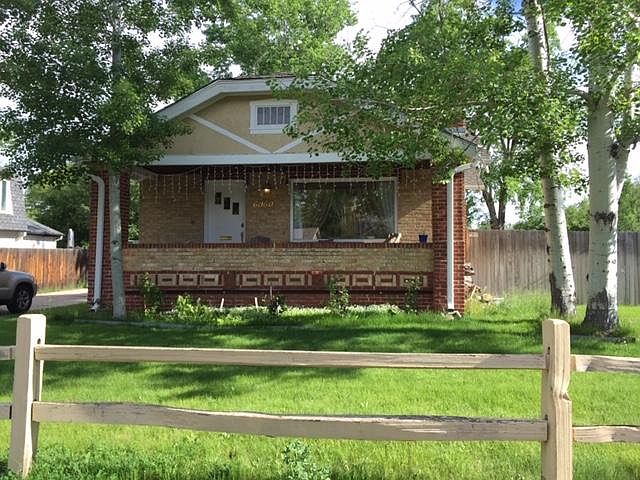 Front of house, with porch across the whole front.