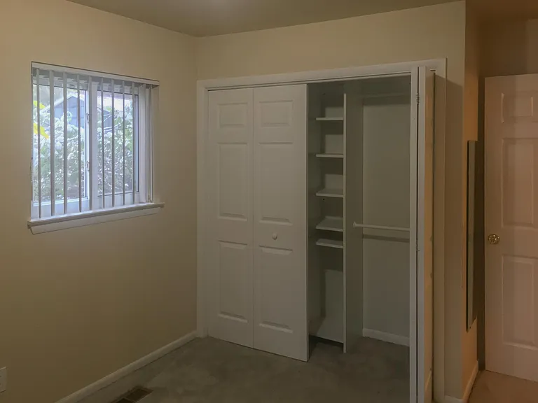 Corner Bedroom, view of side yard window and double folding door closet