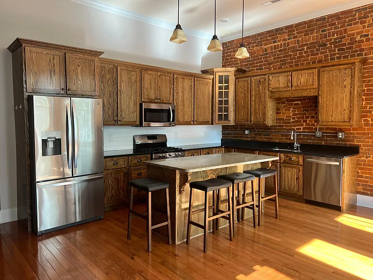 Kitchen with custom cabinets and granite countertops. Stainless steel appliances.
