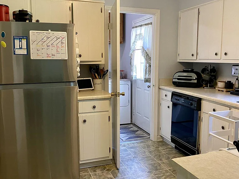 Spacious kitchen with refrigerator, oven, dishwasher, and plenty of cabinets.