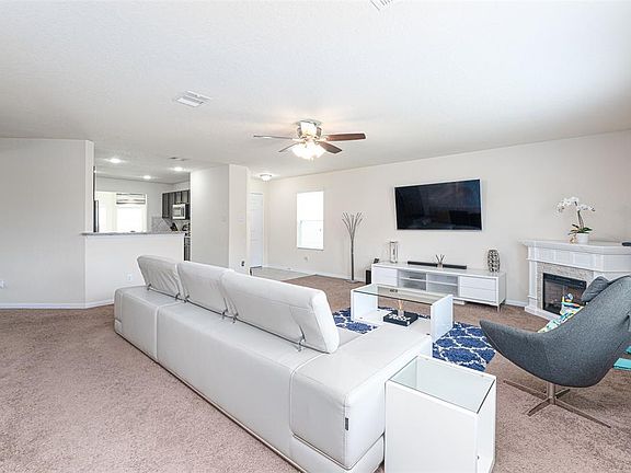 Gather the family and guests together in your lovely living room! Featuring high ceilings, recessed lighting, dark stained ceiling fan, plush carpet, and large windows that provide plenty of natural lighting throughout the day!