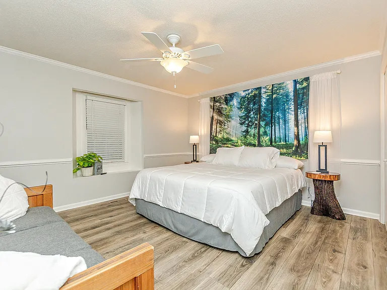 Master King Ensuite Bedroom with sofa, night stands, side lamps and double closets.