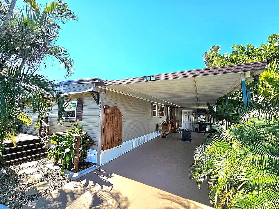 Front of the property, looking at both the front deck as well as the covered 2 car carport
