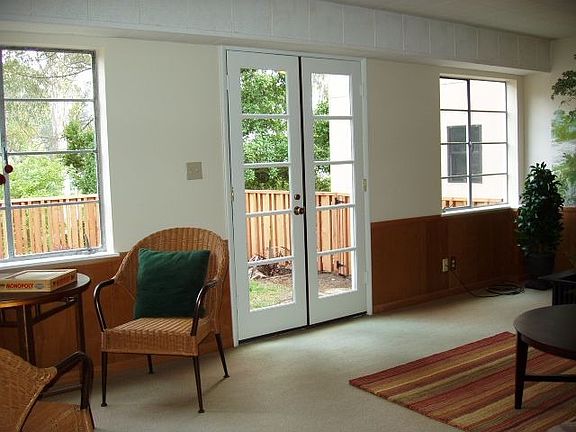 French doors in family room opening to sunny enclosed garden.