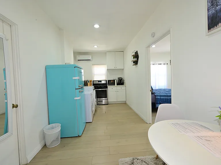 Fully furnished living room with upgraded kitchen, appliances, and laundry machines