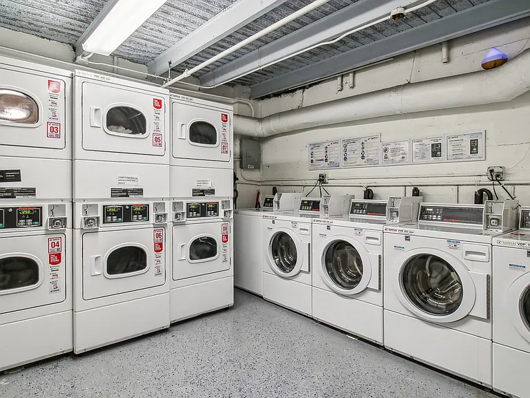 Laundry room with a row of washing machines and dryers