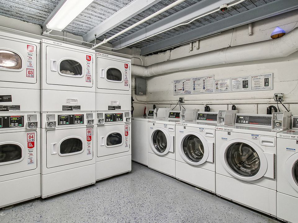 Laundry room with a row of washing machines and dryers
