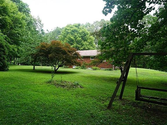 View of rear of home from the edge of where the yard meets the wood acreage