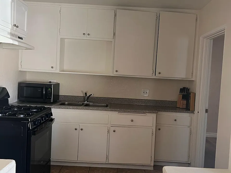 Kitchen includes 4-burner stove with oven and tile floor