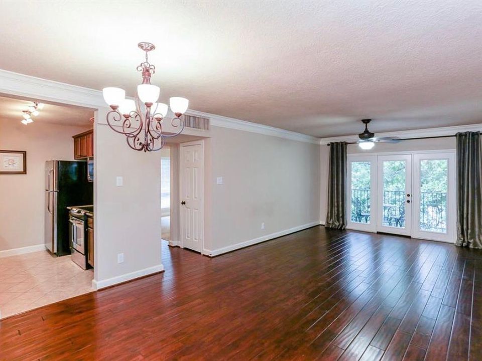 Living area with French doors opening onto the balcony. Dining area and kitchen to the left.