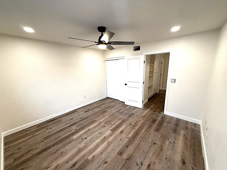 Primary bedroom showing entry to bedroom and door to bath on the left. Bedroom is 12.5 ft wide and 15.5 ft long.