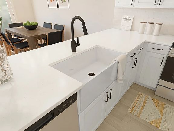 Kitchen with white apron-front sink and matte black fixtures