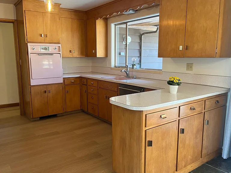 Kitchen looks out to the patio. Plenty of cabinet space. New stainless dishwasher.