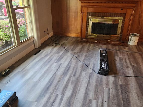 Family room with gas fireplace and large picture window. Wall behind fireplace is now white.