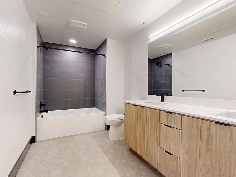 Apartment bathroom with soaking tub and LED lighted mirror.