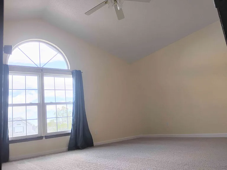 Master bedroom has vaulted ceiling and ceiling fan.