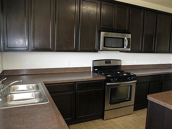 The island kitchen features BEAUTIFUL dark cabinetry with ample storage!