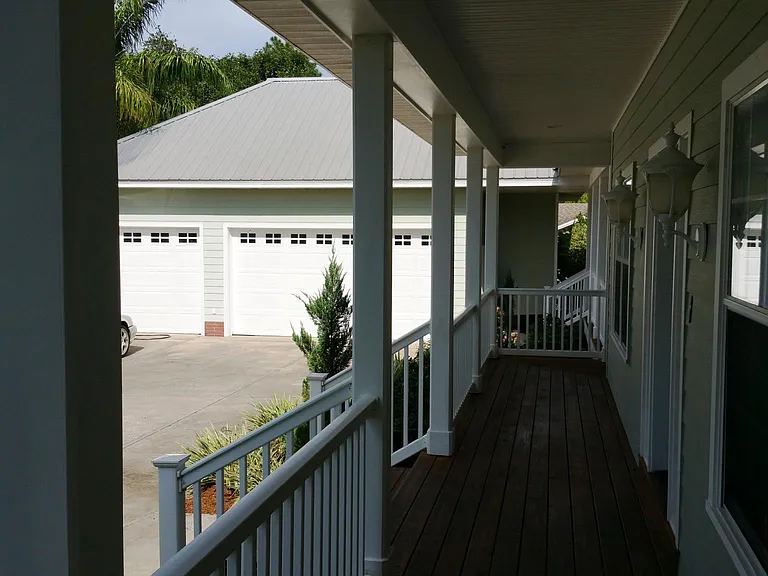 The wrap around porch leading to the three car garage