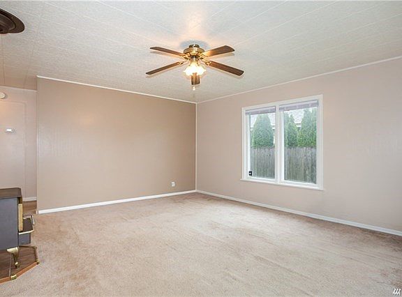 Living room with free standing gas stove attached to wall thermostat