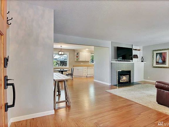 A look into the Living Room, with Dining area and Kitchen beyond. Notice the gorgeous wood floors. What you don't see is the coat closet just beyond the front door, and the wall separating the Living Room from the Dining and Kitchen, because they were removed to create a more open feel to the living area.