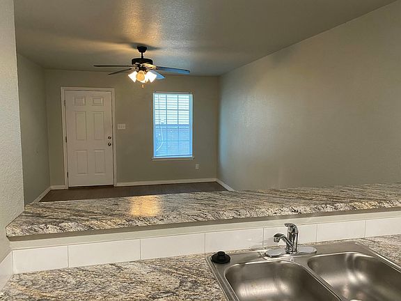 View from kitchen into living room. Neutral paint throughout.